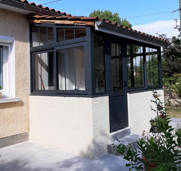Véranda anthracite avec fenêtres et porte, vue d’angle