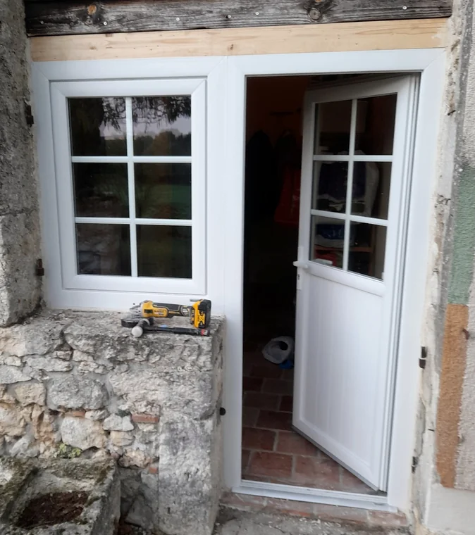 Ensemble blanc comprenant une fenêtre à petits bois et une porte ouverte